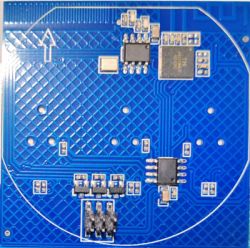Blue PCB with surface-mounted components and a white circular outline