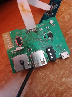 Płytka drukowana z zaznaczonym elementem i widocznymi portami USB oraz przewodem.