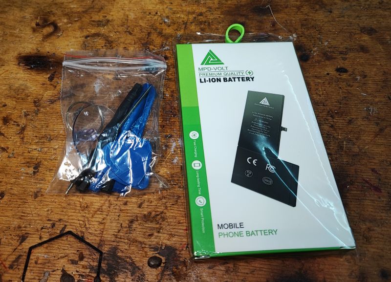 iPhone Battery Replacement Kit iPhone battery replacement kit showing a battery package and tools in a ziplock bag.