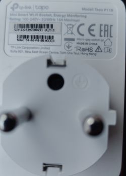 Close-up view of the back of a TP-Link Tapo P110 smart plug with visible markings and prongs.