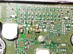 Zbliżenie na zieloną płytkę PCB z wieloma komponentami elektronicznymi SMD.