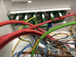 Zbliżenie na płytkę elektroniczną z bezpiecznikami i podłączonymi przewodami w obudowie