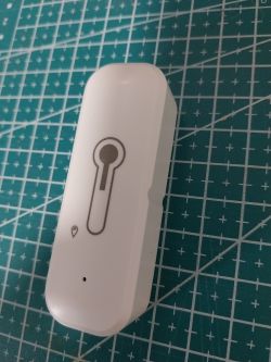 White device with a thermometer icon on a green grid cutting mat.