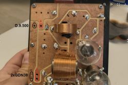 Zbliżenie na płytkę drukowaną z cewką i elementami elektronicznymi.