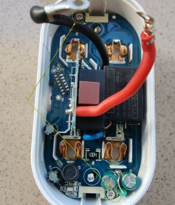 Interior of a smart plug showing the mainboard and attached wires.