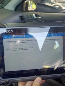 Tablet z diagnostyką samochodową w aucie, pokazujący kody błędów dotyczące mieszanki paliwa i czujnika tlenu.