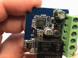 Electronic module with relay and screw terminal connector Close-up of a blue PCB with electronic components and a green screw terminal