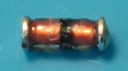 Mały element elektroniczny z jednym czarnym paskiem przez środek, prawdopodobnie dioda Zenera.