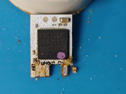 Close-up of a PCB module with SV6166F chip removed from a Sonoff lamp, placed on a blue surface.