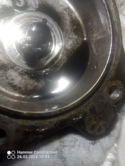 Metalowa powierzchnia z elementem w środku, prawdopodobnie część mechaniczna.
