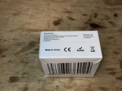 Packaging of WSM16-W1 relay module on a wooden background