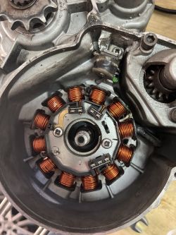 Stator silnika z widocznymi śrubami mocującymi.