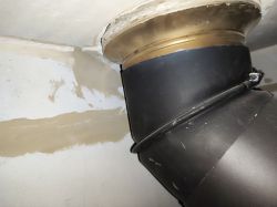Fireplace component with a black pipe attached to the ceiling.