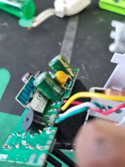 Close-up of a circuit board with a CB2S Wi-Fi module and three electrolytic capacitors.