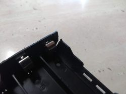 Cracked Slot in Plastic Battery Holder Close-up of a cracked battery holder slot in a plastic cell holder.