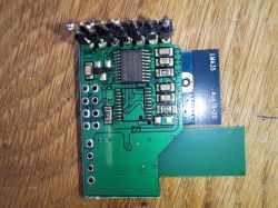 Printed circuit board with integrated circuit, markings, and pins.
