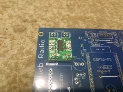 Small green electronic module on a blue PCB labeled “Web Radio” and “ESP32-S3”.