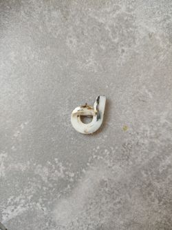Niezidentyfikowany biały element plastikowy na szarej powierzchni