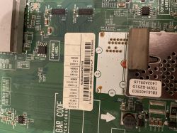 Płytka drukowana z różnymi elementami elektronicznymi i naklejkami kodu kreskowego.
