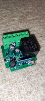 Relay module on a circuit board with green terminals.