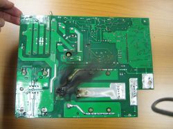 Uszkodzona płytka PCB z ciemnym, zwęglonym obszarem.