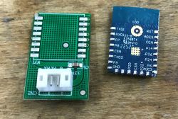 WiFi module next to programming interface board on wooden surface