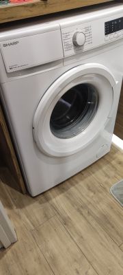 Pralka Sharp ES-HFA 6103W3 z drzwiami frontowymi w łazience na panelach