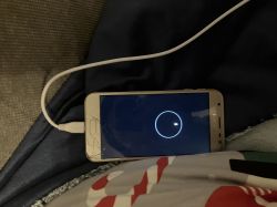 Telefon Samsung J3 2017 podłączony do ładowarki z czarnym ekranem i białą ikoną ładowania.