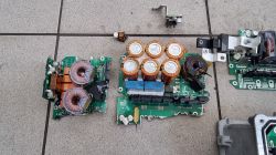 Rozebrane elementy wnętrza ładowarki elektrycznego samochodu na podłodze.