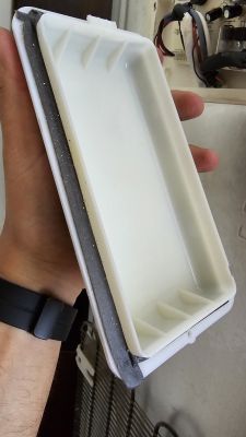 Osoba trzymająca w ręku pokrywę z tworzywa sztucznego z metalową obejmą.