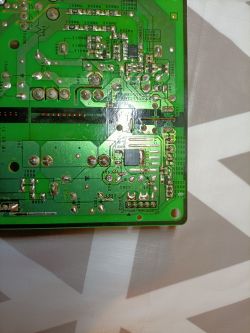 Zbliżenie na zieloną płytkę drukowaną z widocznymi obwodami i komponentami elektronicznymi.