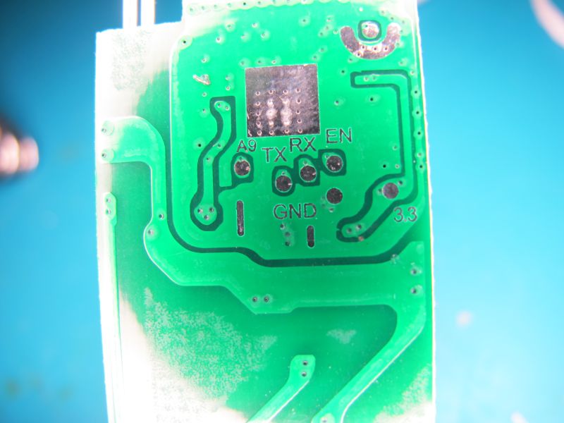 Close-up of PCB with labeled pin connections Close-up of green circuit board with labels TX, RX, GND, and 3.3