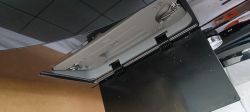 Otwarta klapka obudowy wymiennika ciepła suszarki Samsung, widoczne zawiasy i wnętrze klapki.