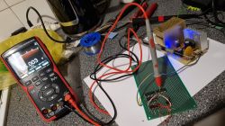 Voltage measurement in circuit with NE555 and logic gates Test circuit with digital multimeter and prototyping board with measurement probes connected.