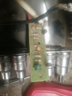 Płytka drukowana z elementami elektronicznymi, w tym rezystorami i kondensatorami.