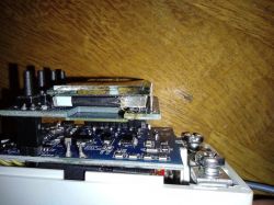 Stack of circuit boards mounted against a wooden background.