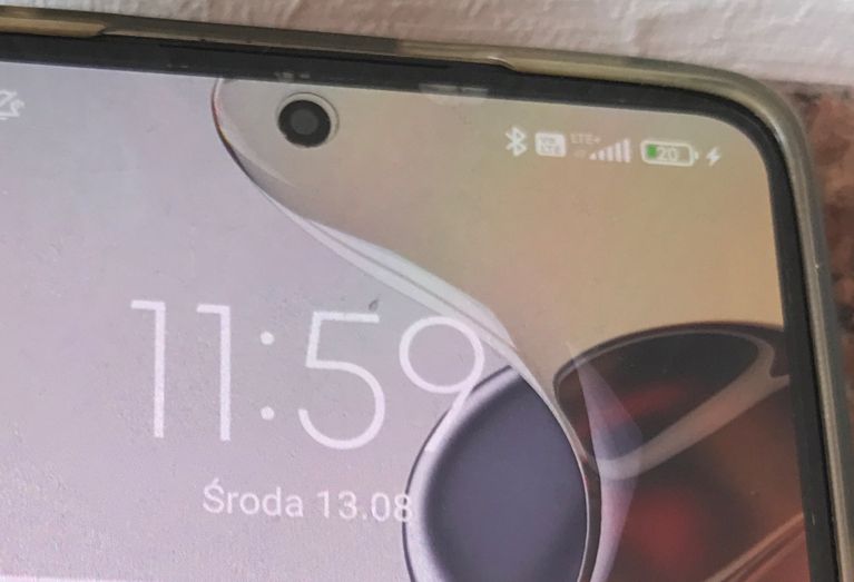 Zbliżenie ekranu smartfona z godziną 11:59 i baterią na poziomie 20%