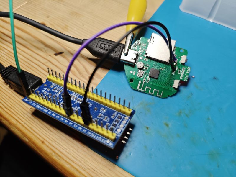 Connected electronic boards on a workbench Development board with jumper wires connected to a green PCB with microUSB port