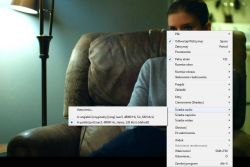 Osoba siedzi w fotelu z otwartym menu kontekstowym programu Media Player Classic; zaznaczona opcja wyboru ścieżki audio.