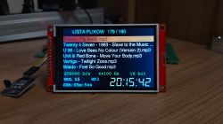 Small LCD screen showing MP3 file list with song and audio playback details.