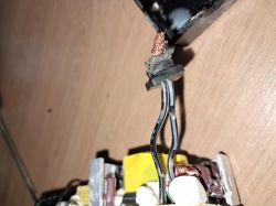 Zbliżenie na dwa przewody elektryczne, czarny z widocznym drutem miedzianym.