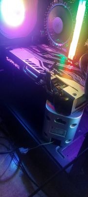Widok wnętrza obudowy komputera z kartą graficzną Sapphire i podświetleniem RGB.