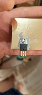 Podzespół elektroniczny, prawdopodobnie triak BTB16, przymocowany do metalowej płytki.