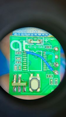 Printed circuit board (PCB) with electronic components and a blue wire.