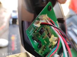 Zbliżenie na płytkę drukowaną z przymocowanymi przewodami wewnątrz urządzenia.