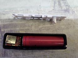 Otwarte etui power banku z widoczną czerwoną baterią 18650