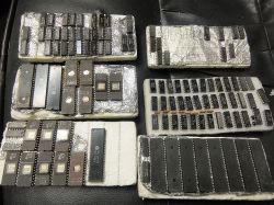 Zestaw różnych układów scalonych na tackach wyłożonych folią aluminiową i pianką