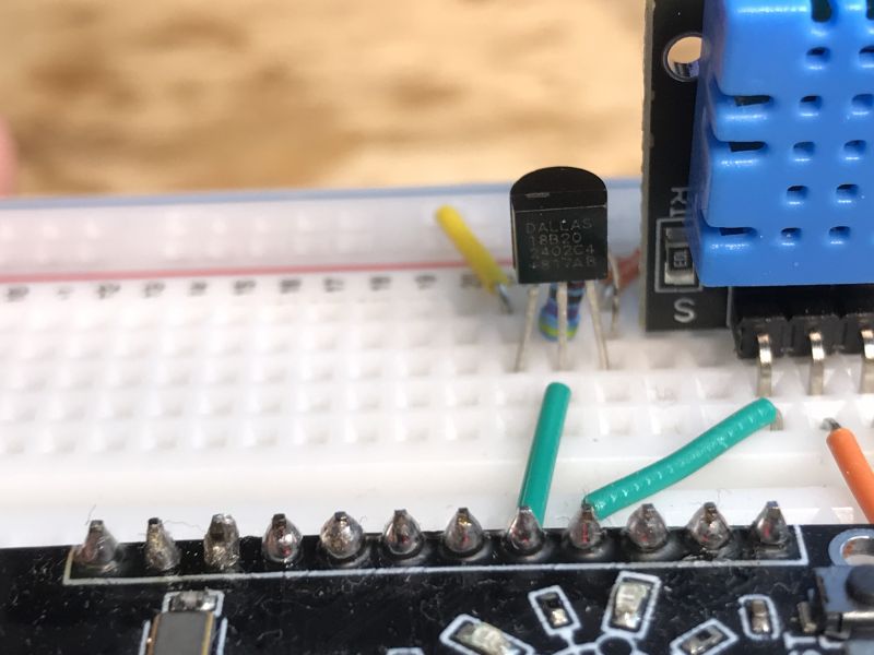Close-up of a DS18B20 chip on a breadboard with colored wires.