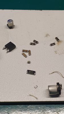 Elementy elektroniczne na białej powierzchni, w tym kondensatory i rezystory.