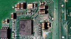 Zbliżenie na płytkę drukowaną z mikrokontrolerem i elementami elektronicznymi.